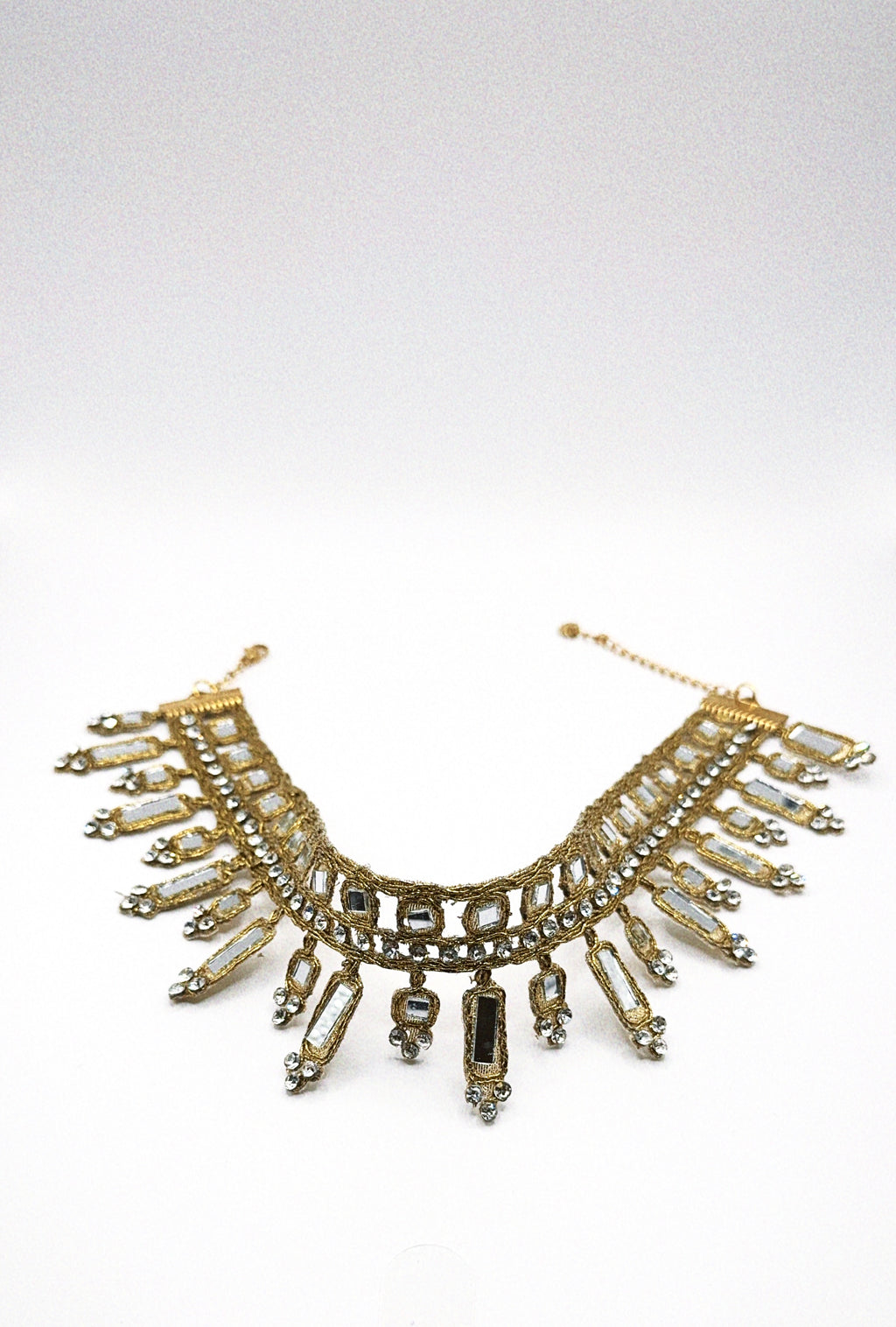 Gold and crystal necklace on a white background