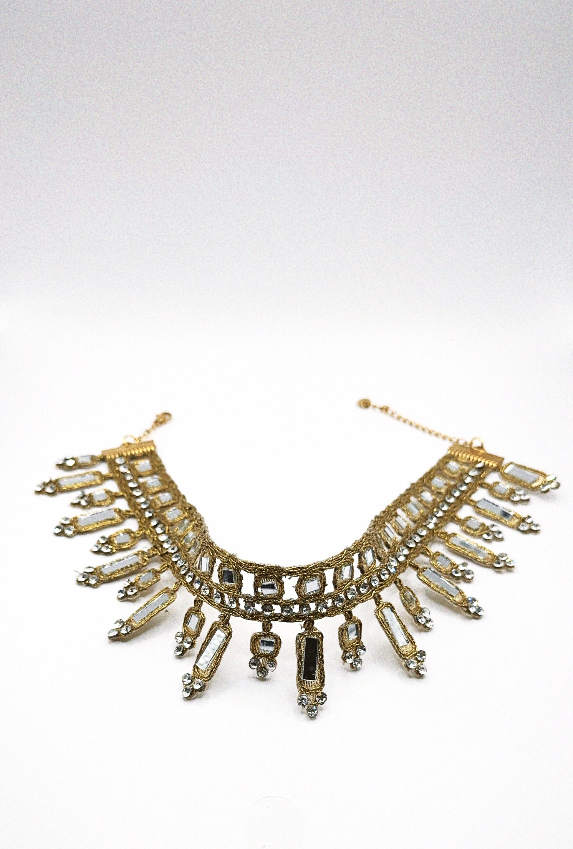 Gold and crystal necklace on a white background