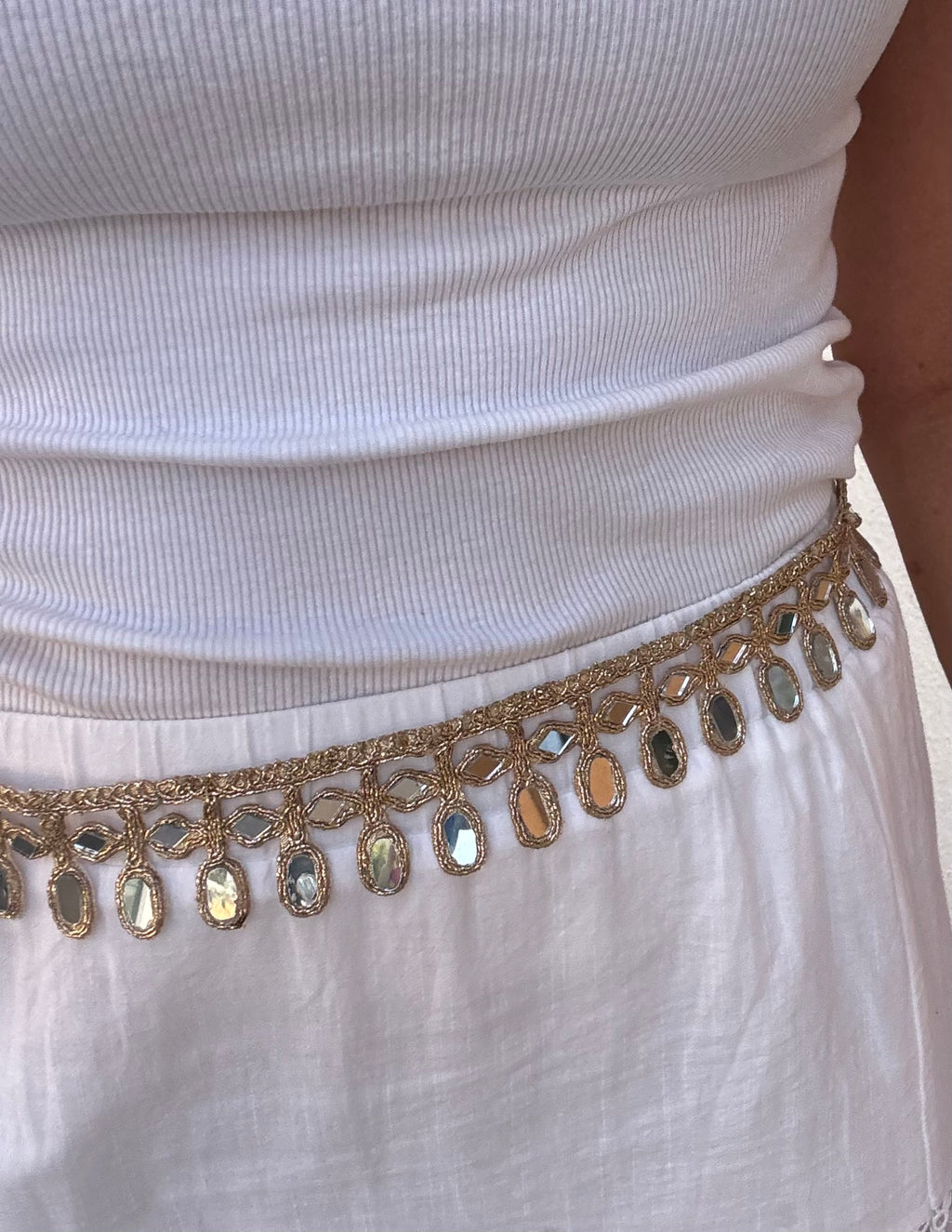 White top with a gold embellished belt