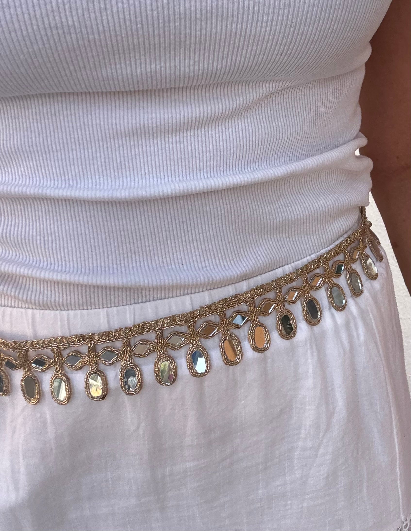 White top with a gold embellished belt