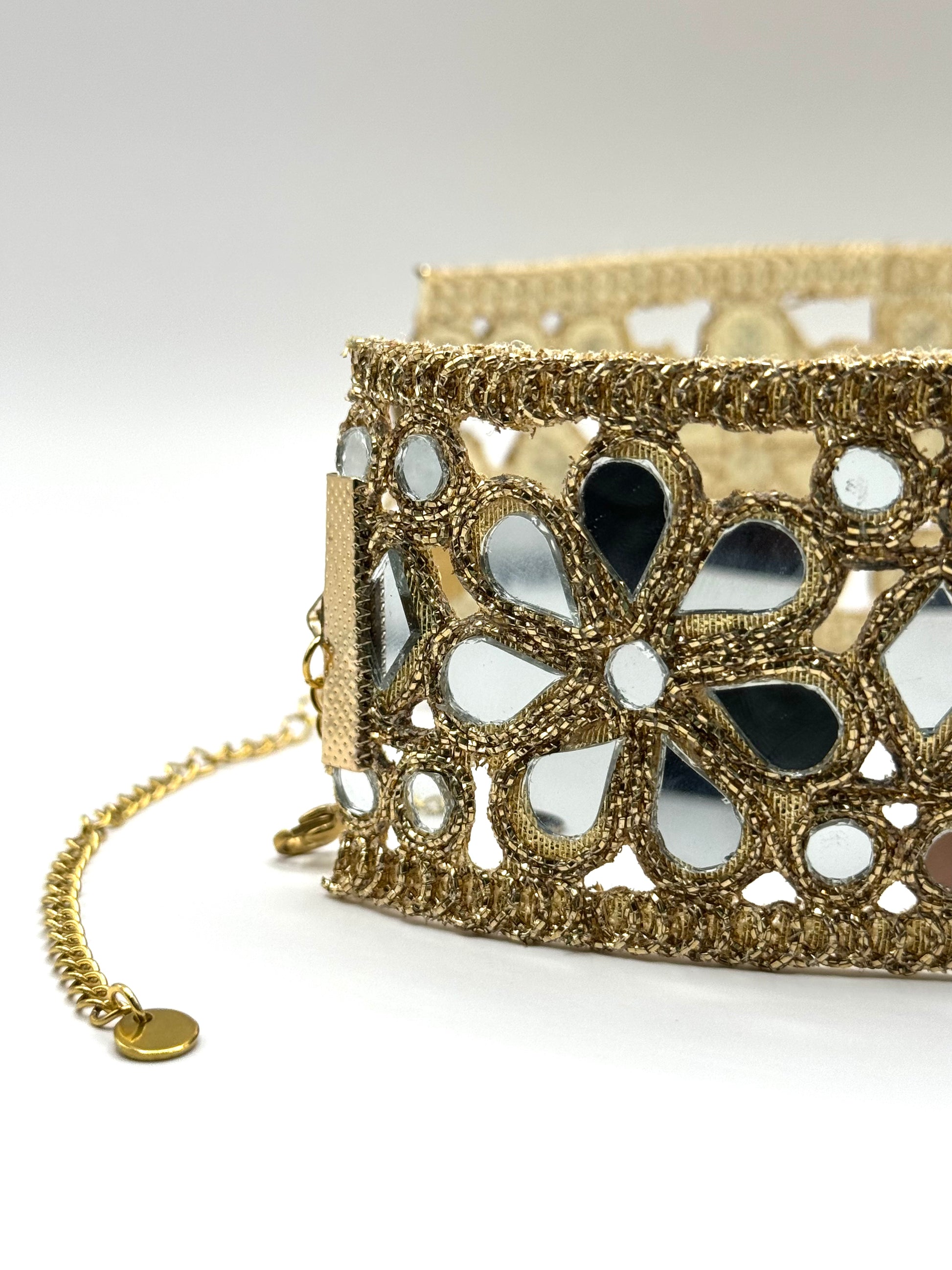 Gold bracelet with floral design on a white background