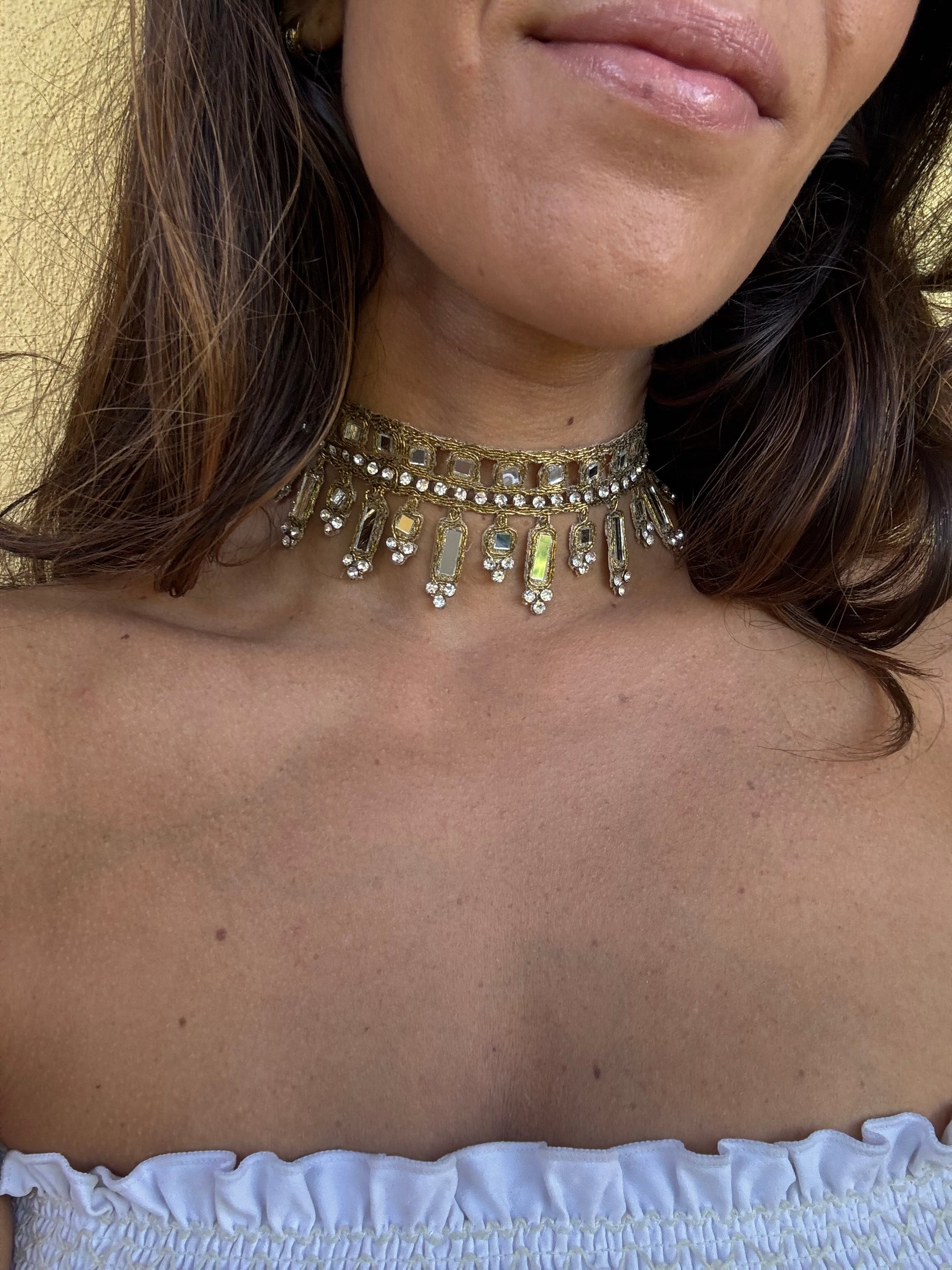 Close-up of a person wearing a decorative necklace with a blurred background