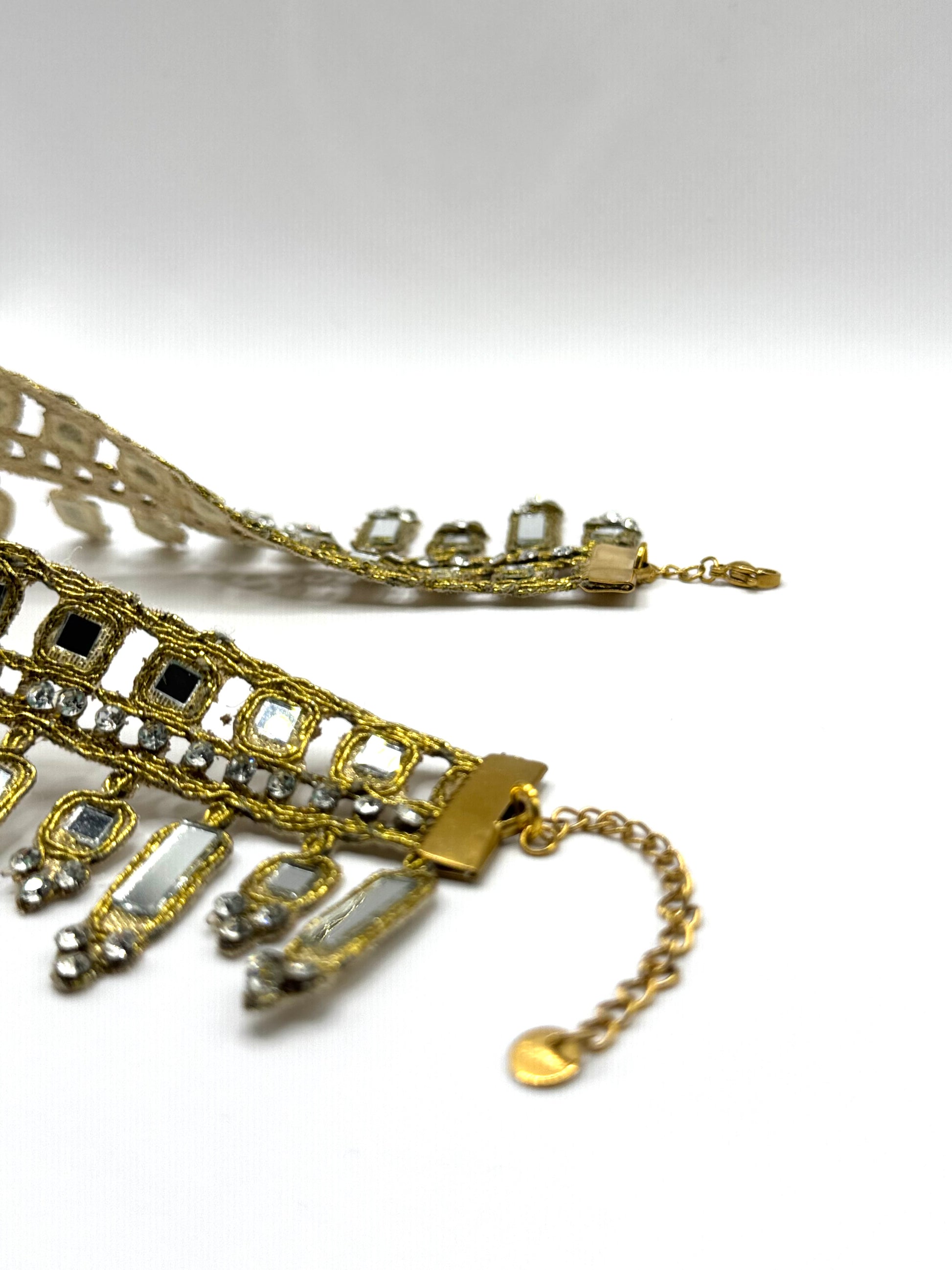 Gold necklace with decorative elements on a white background