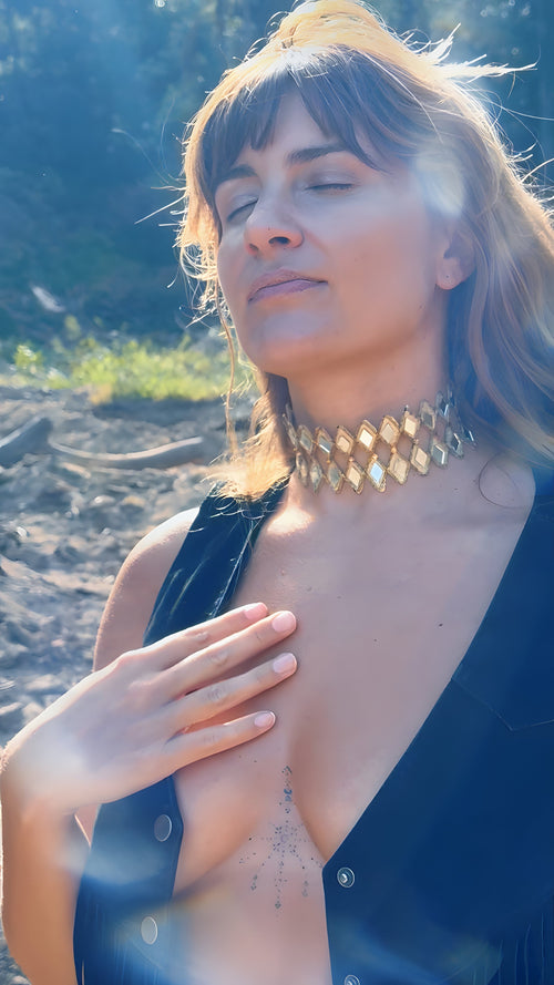 Woman wearing a black top with a necklace on a beach