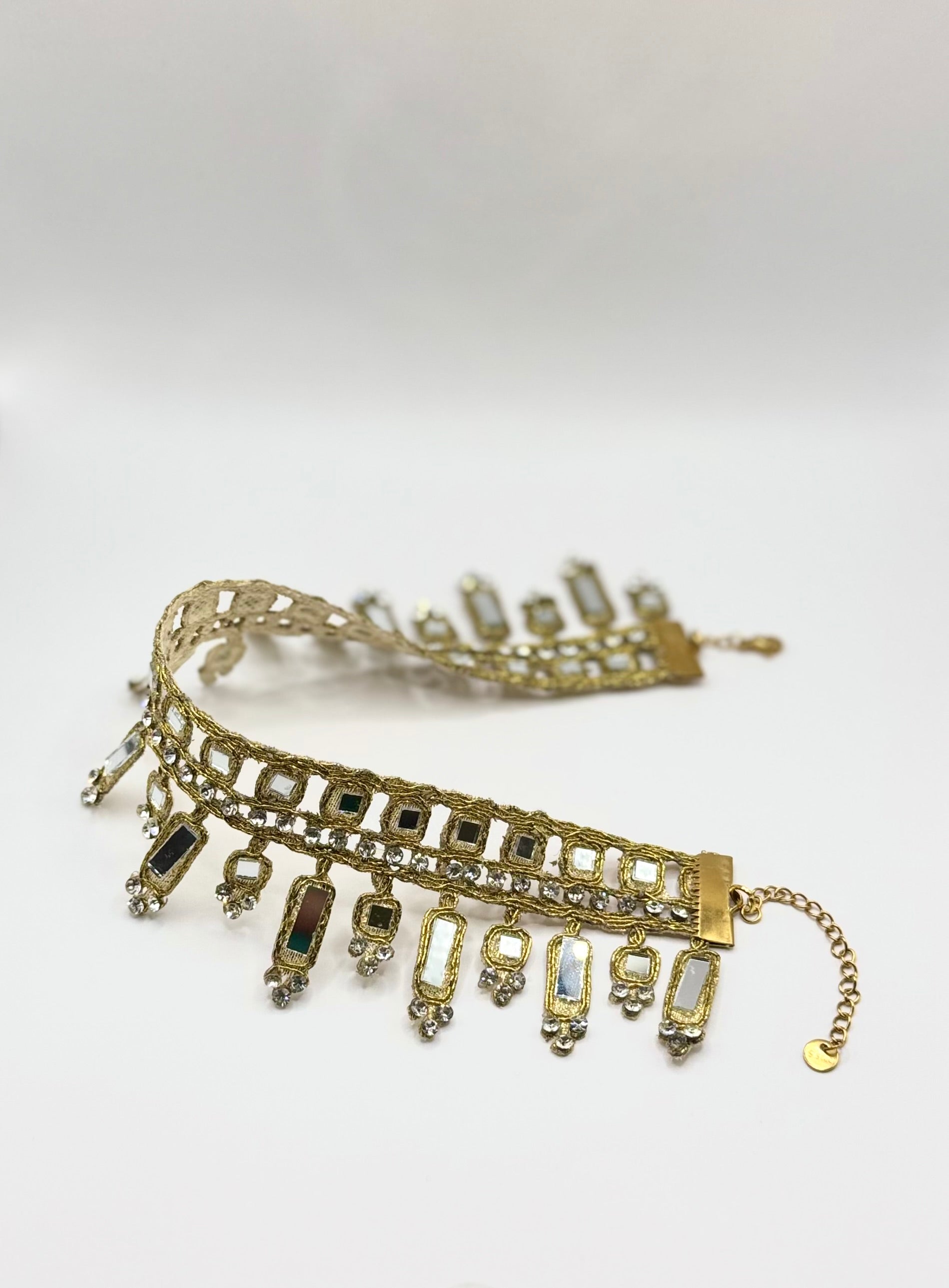 Gold bracelet with charms on a white background