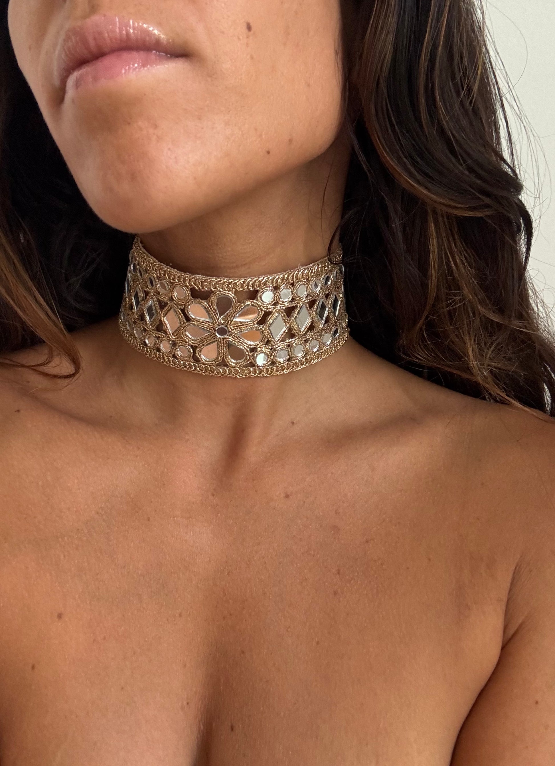 Close-up of a person wearing a decorative silver choker necklace.