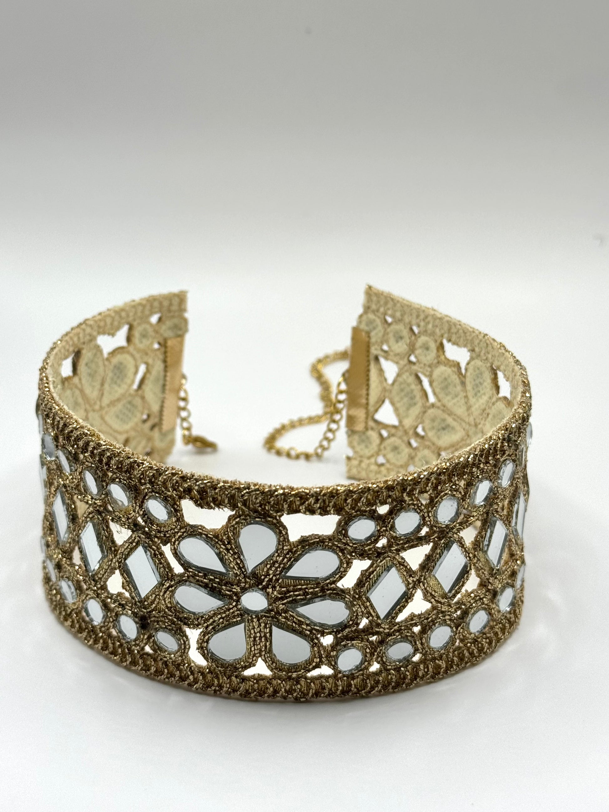 Gold lace choker necklace on a white background