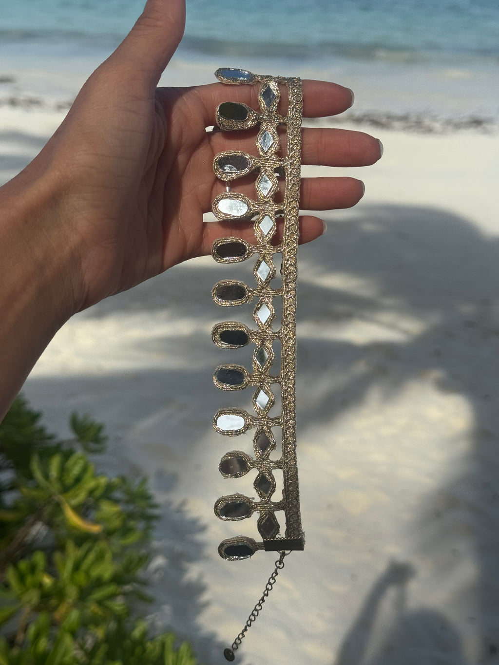 Decorative headband held by a hand on a beach