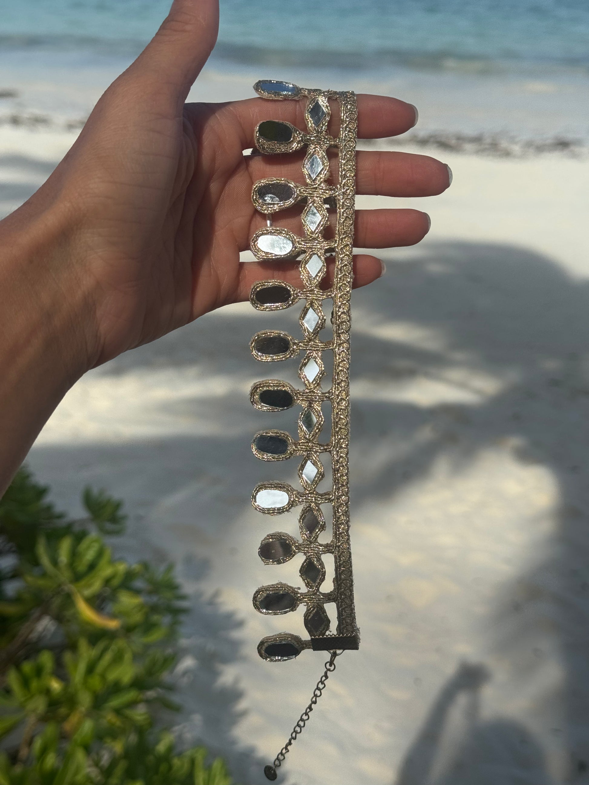 Decorative headband held by a hand on a beach