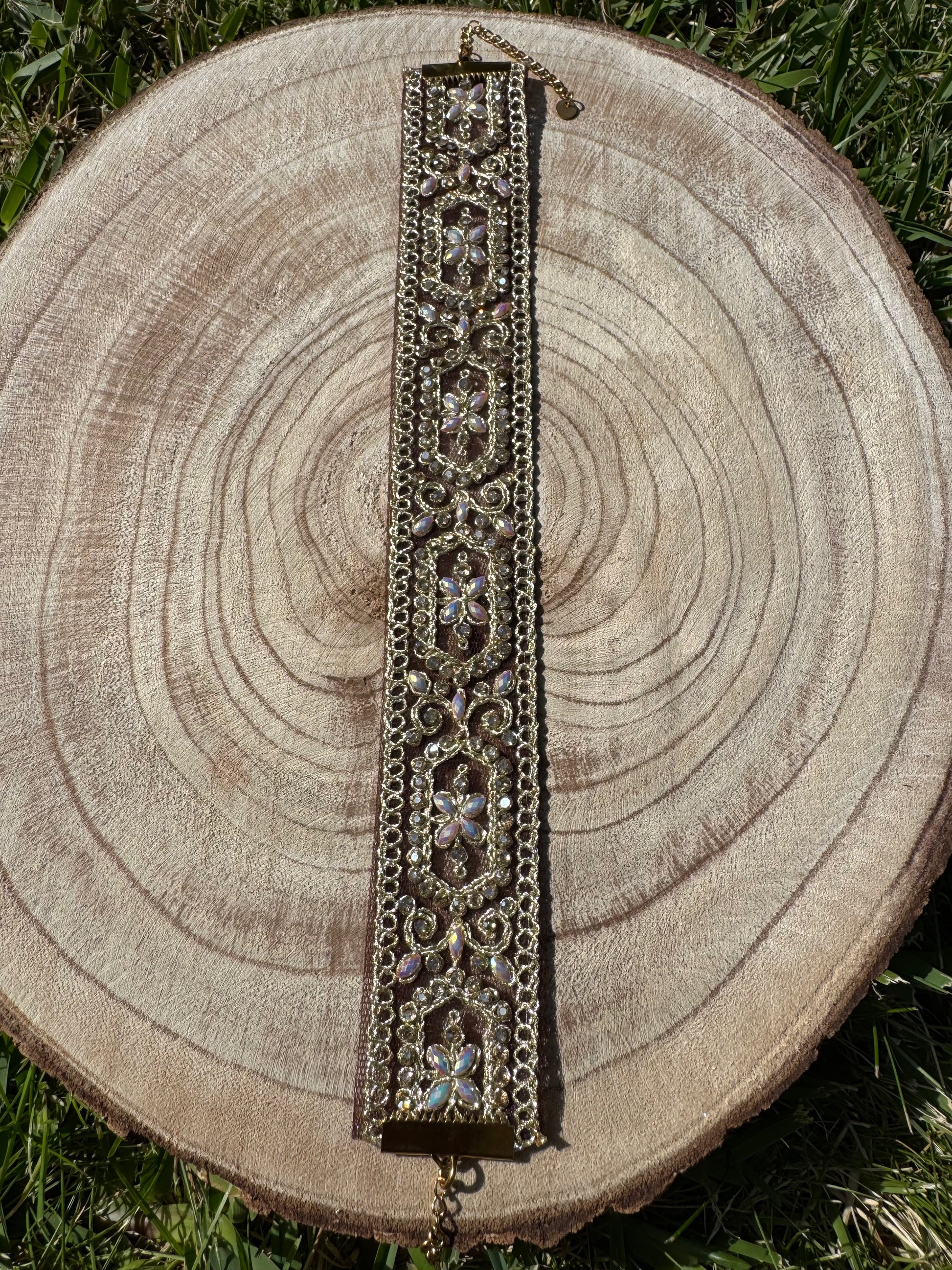 Decorative bracelet on a wooden stump with grass in the background