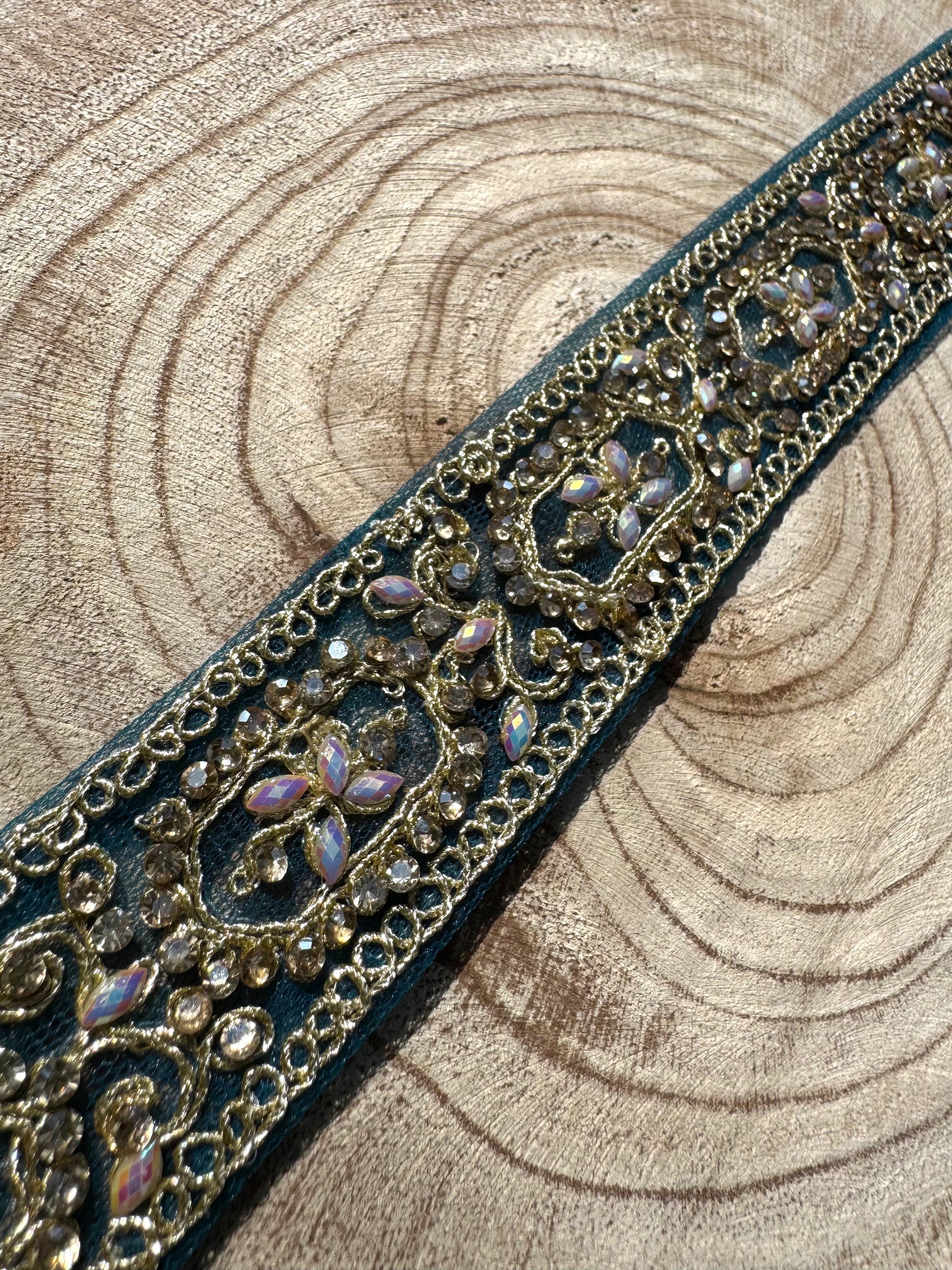 Decorative ribbon with intricate gold and purple pattern on a wooden background