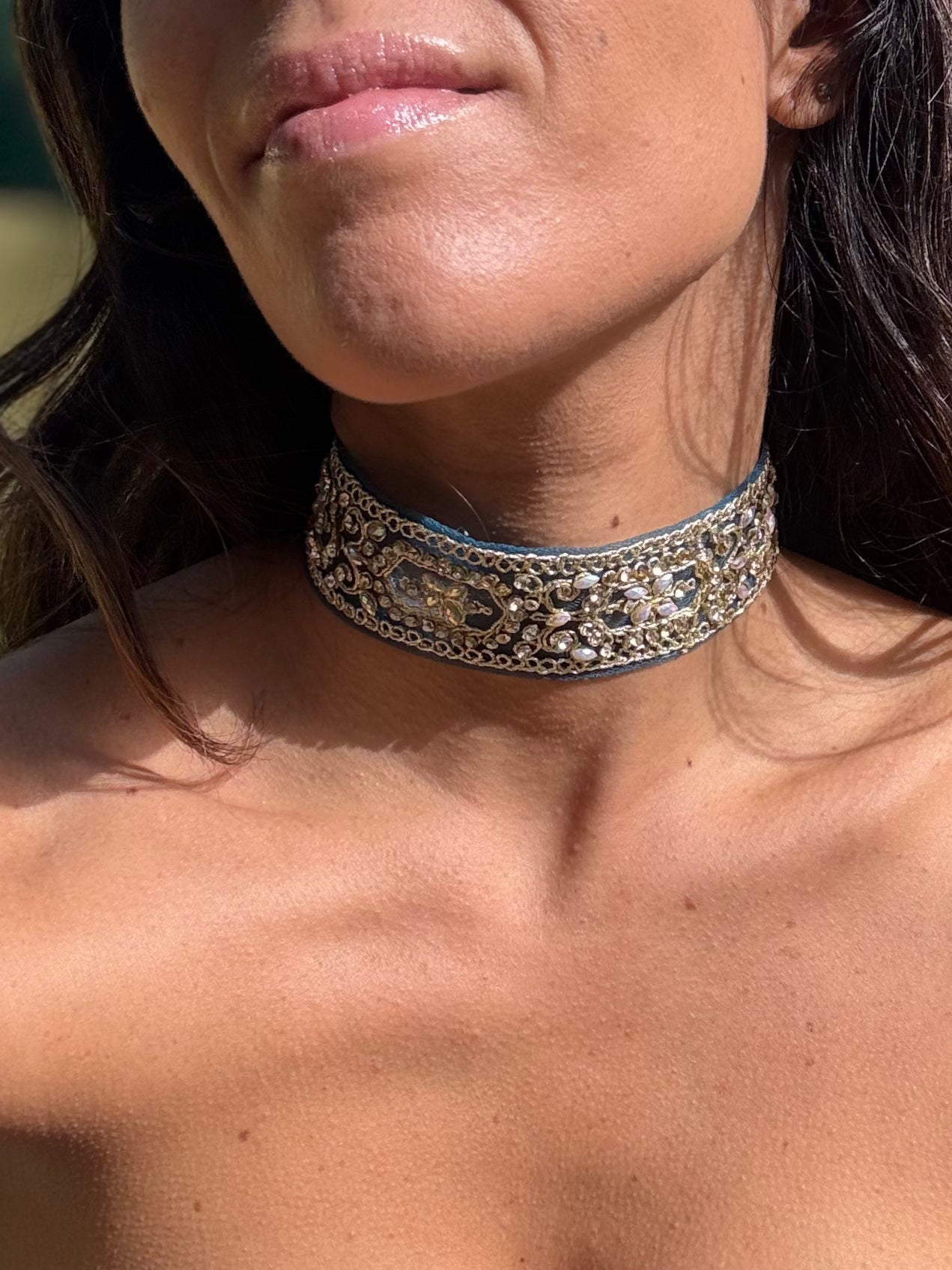 Close-up of a person wearing an ornate choker necklace.