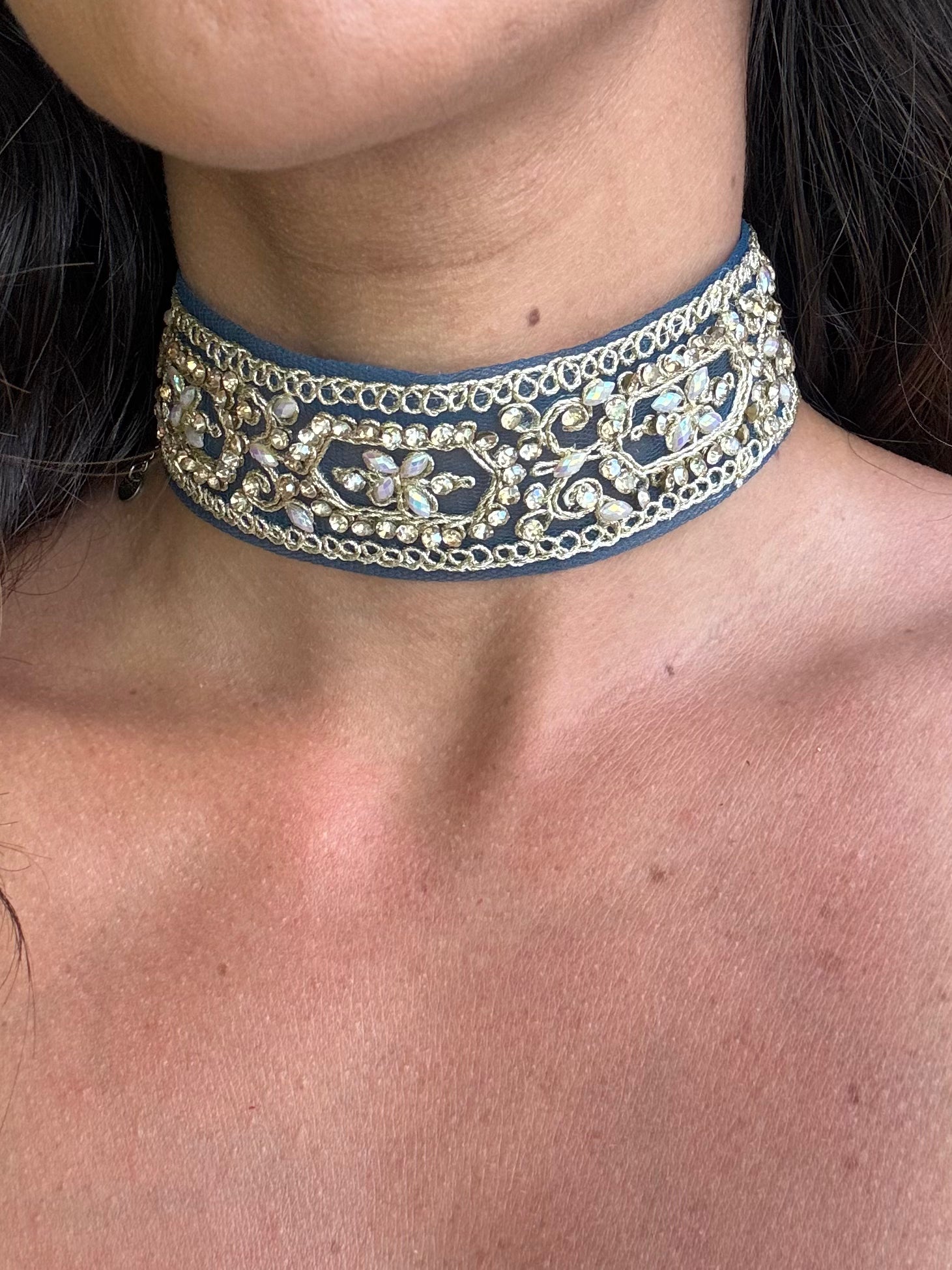 Close-up of a person wearing an ornate blue and silver choker necklace.