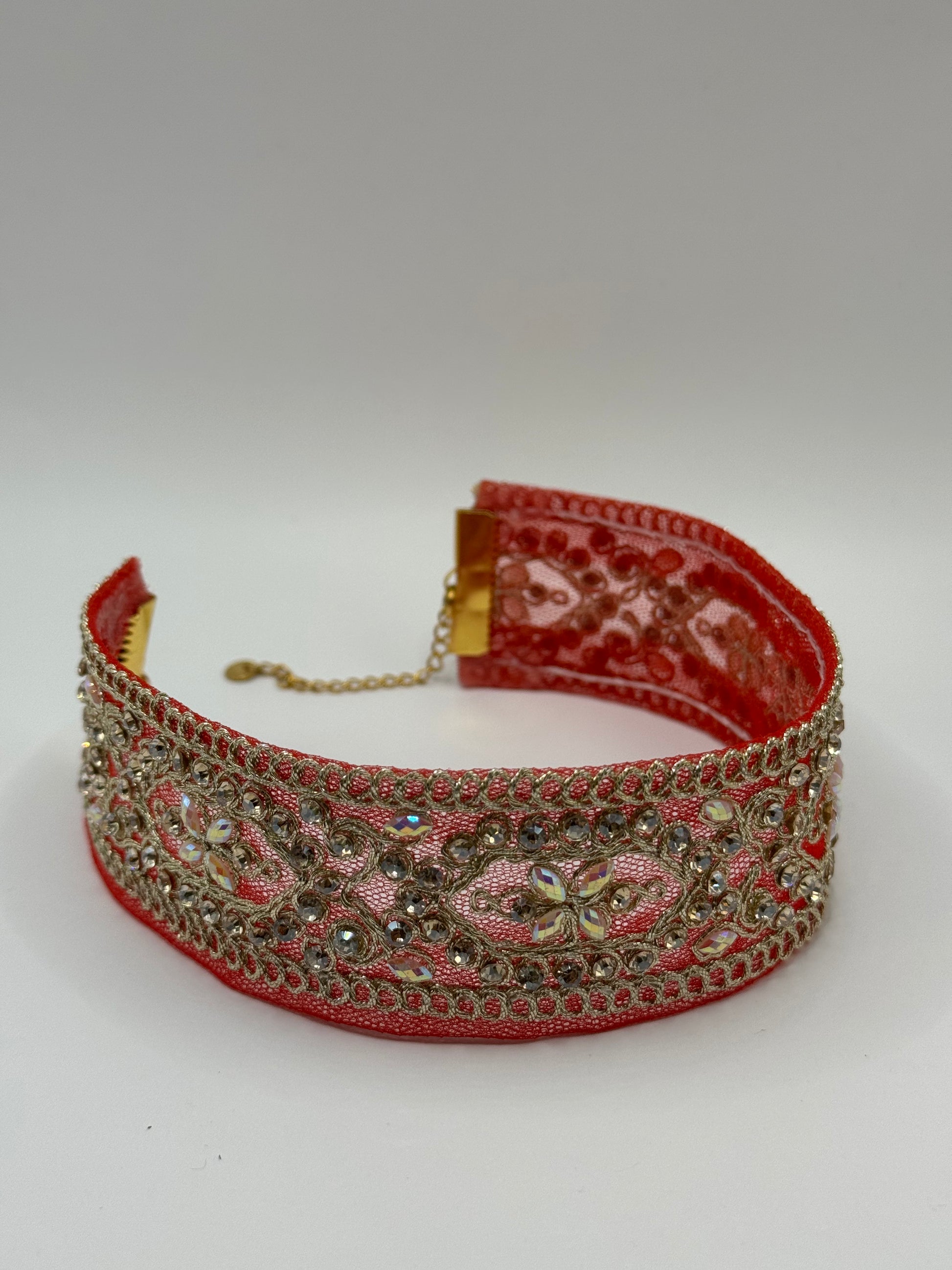 Decorative red headband with gold embellishments on a white background