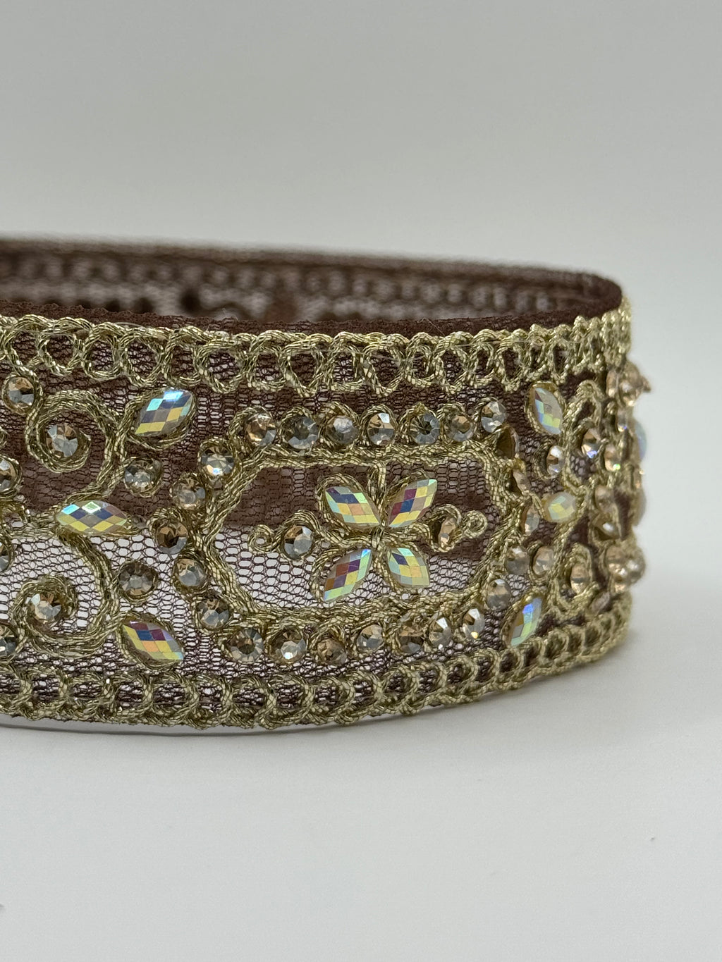 Decorative ribbon with gold lace and rhinestones on a white background