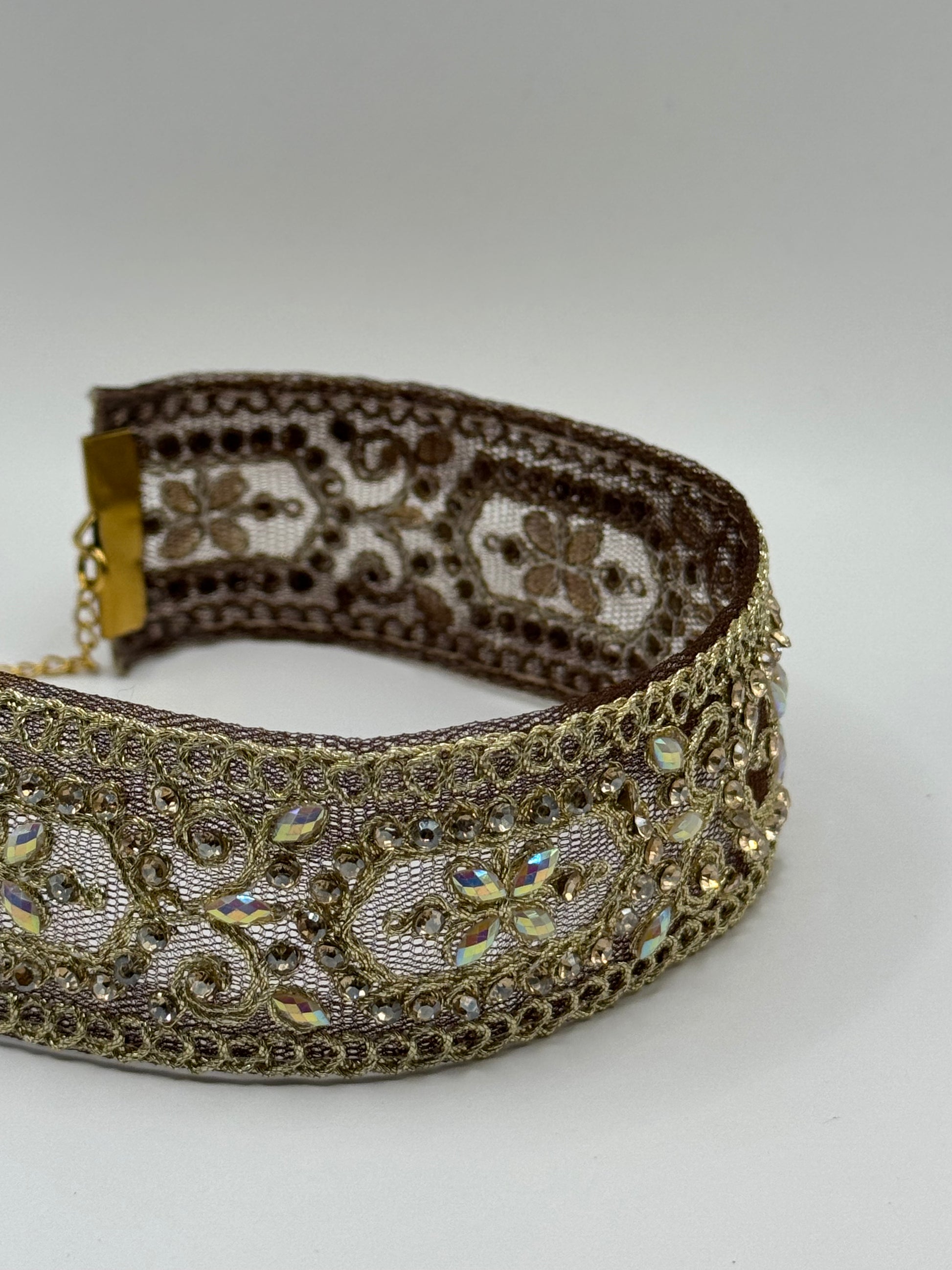 Decorative headband with intricate gold and brown patterns on a white background