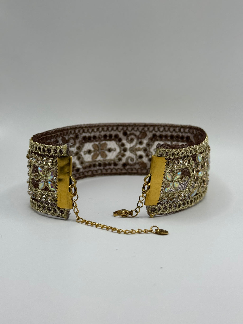 Decorative bracelet with intricate patterns and gold accents on a white background