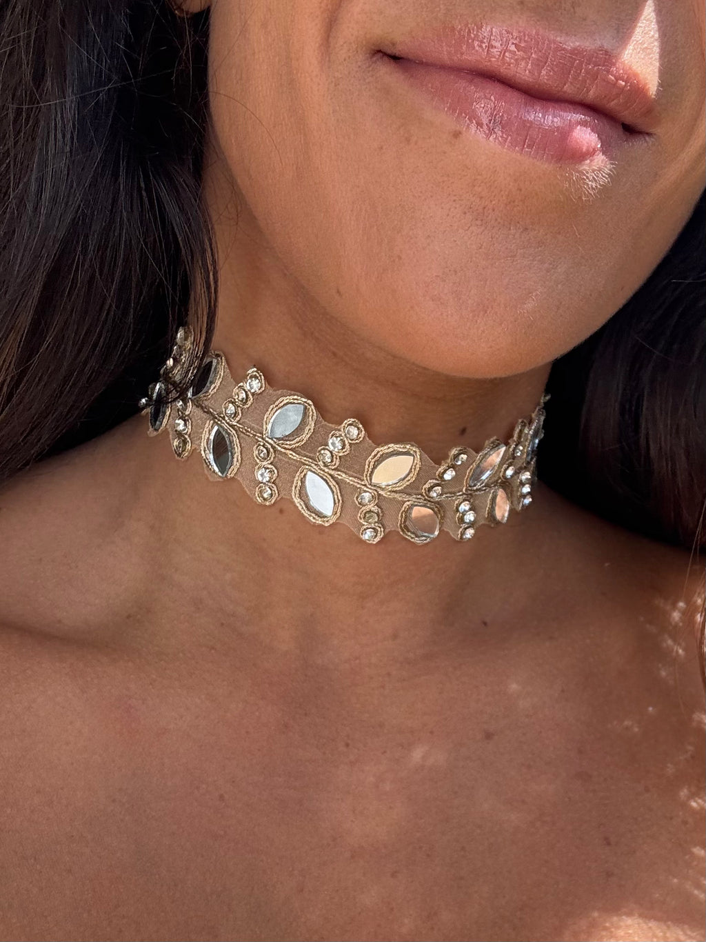 Close-up of a person wearing an ornate choker necklace.