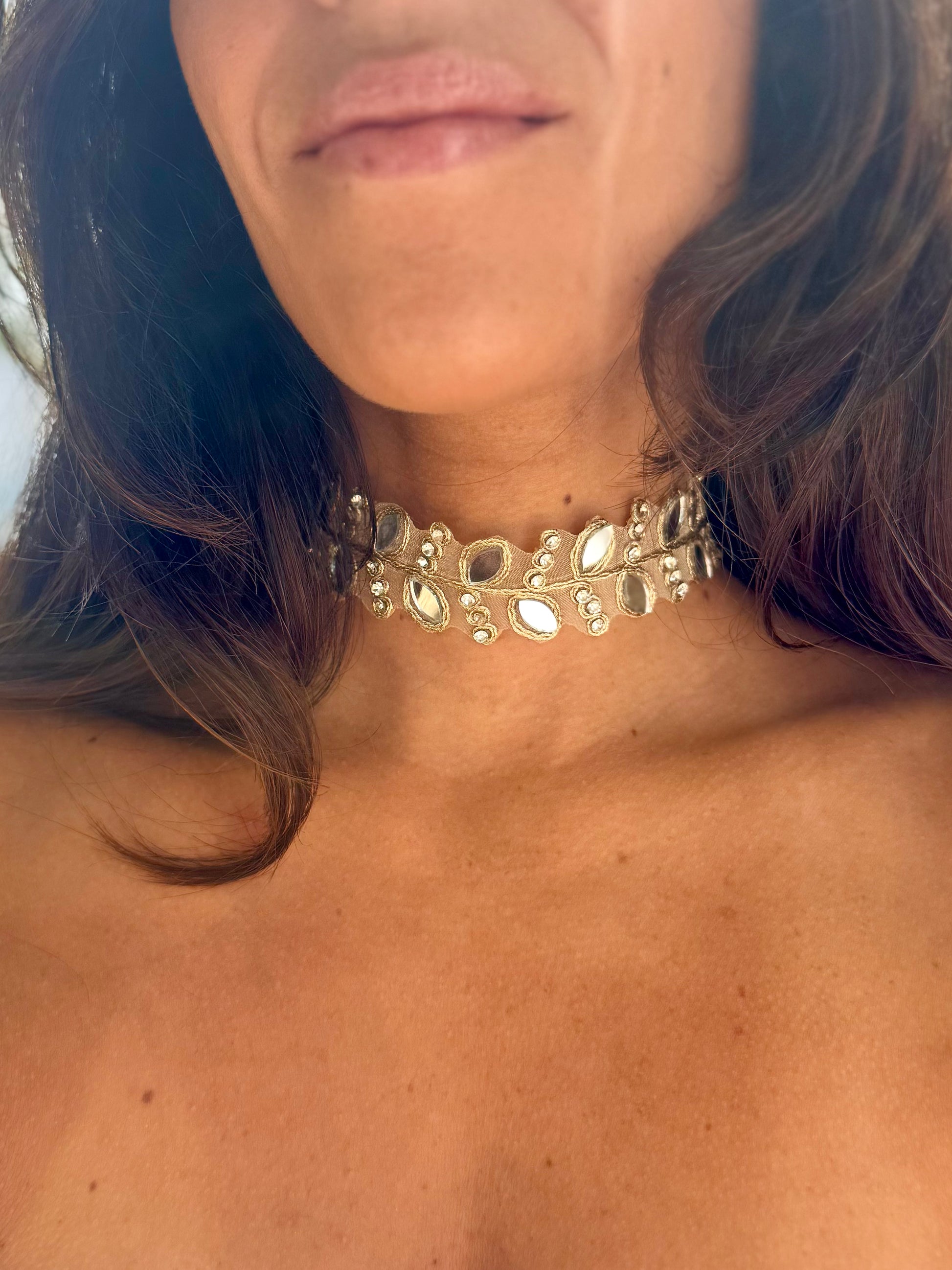 Close-up of a person wearing a decorative silver choker necklace.