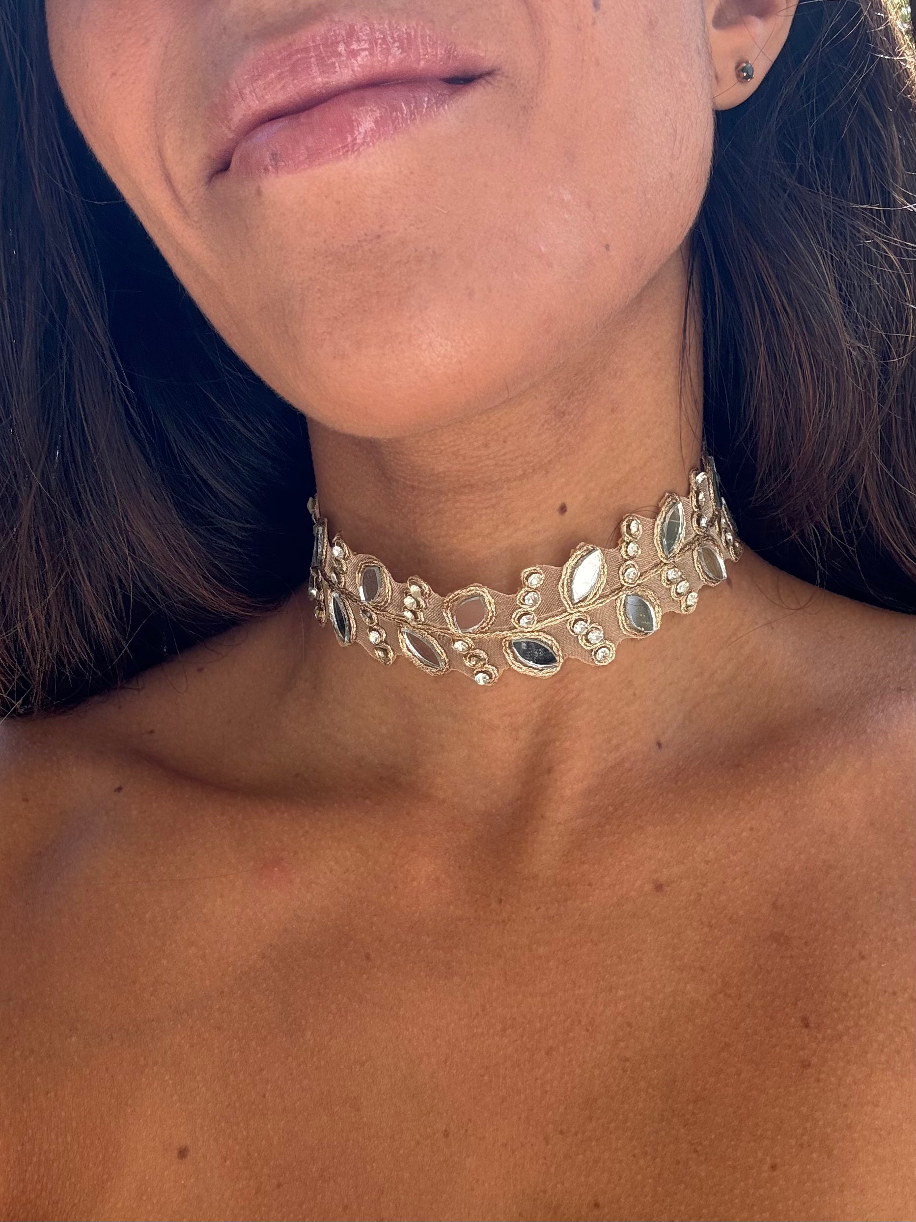 Close-up of a woman wearing a decorative gold choker necklace.