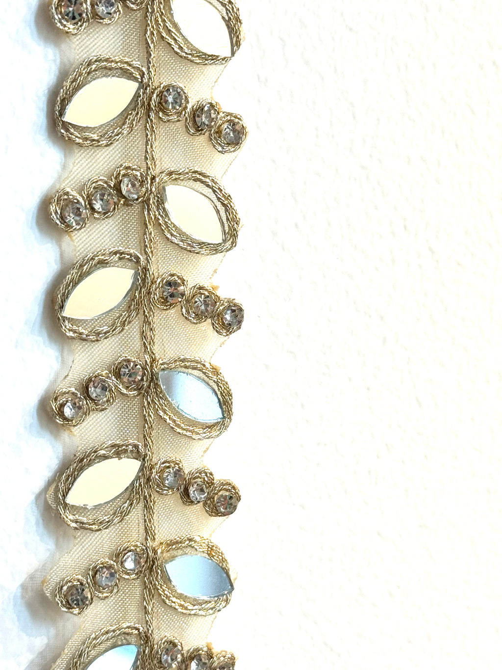 Decorative ribbon with gold and silver embellishments on a white background