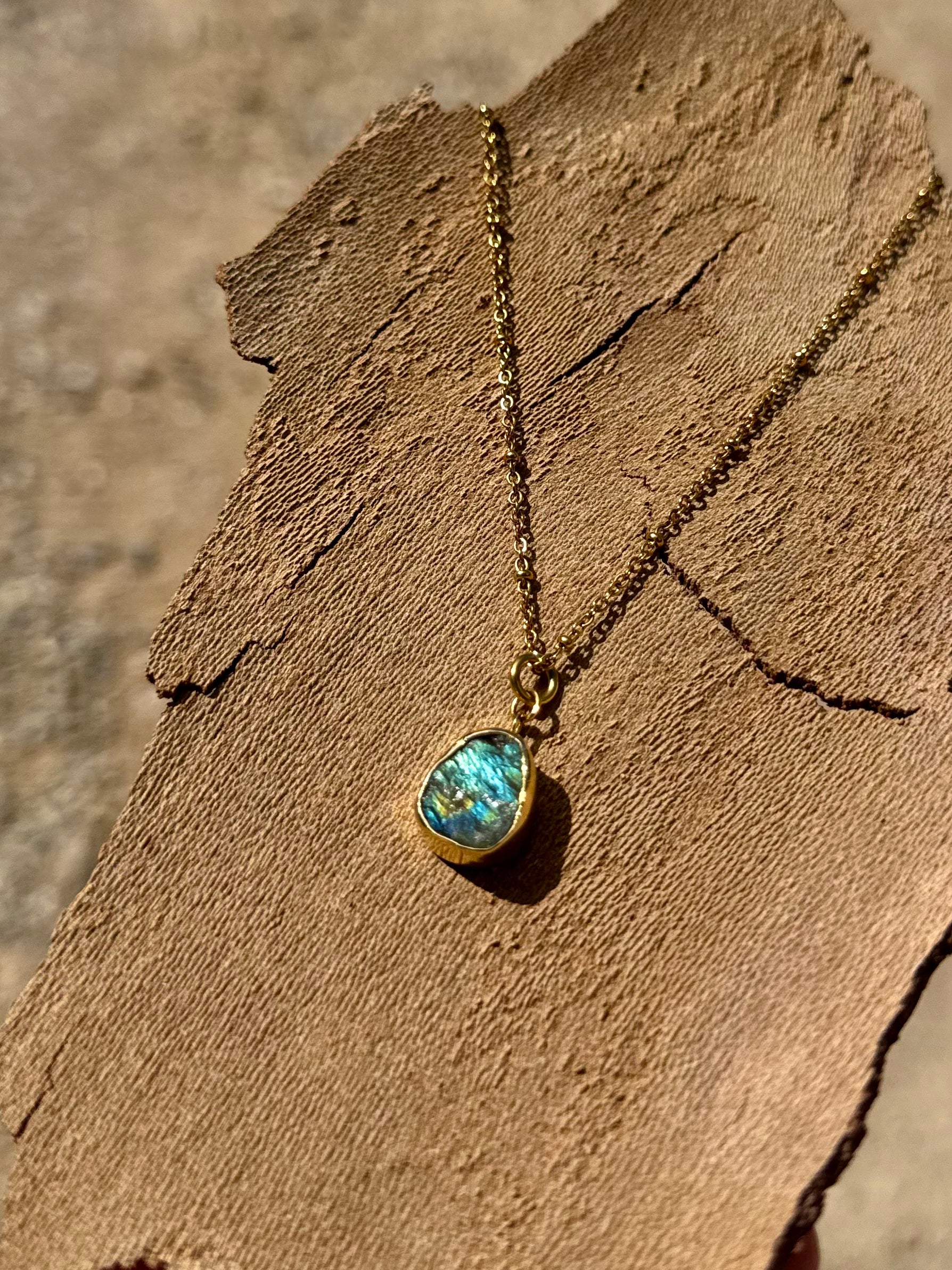 Necklace with a blue pendant on a wooden surface