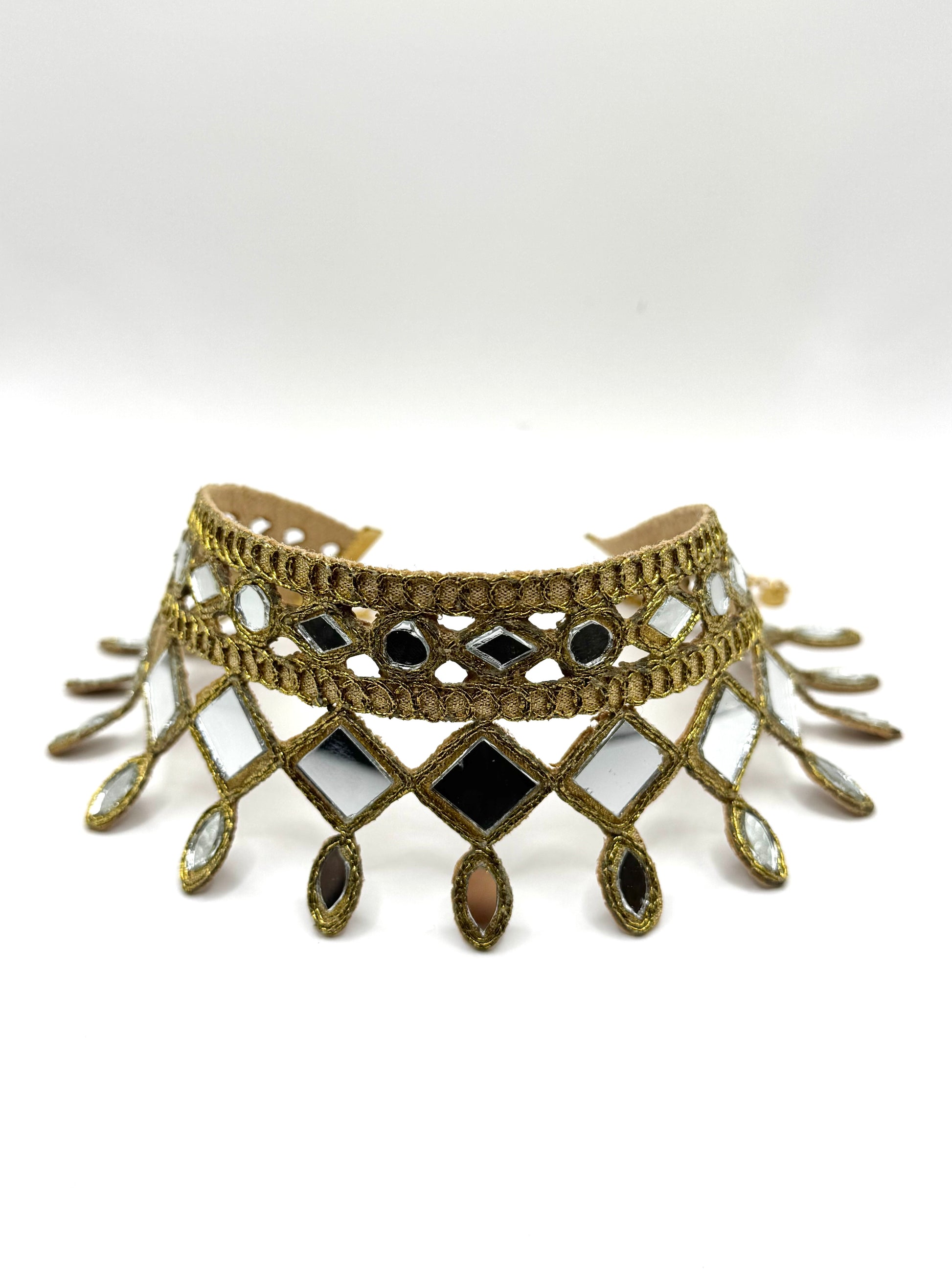 Decorative choker necklace with intricate design and black stones on a white background